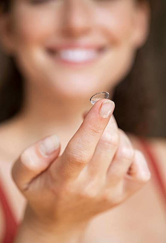 A patient holding a contact lens